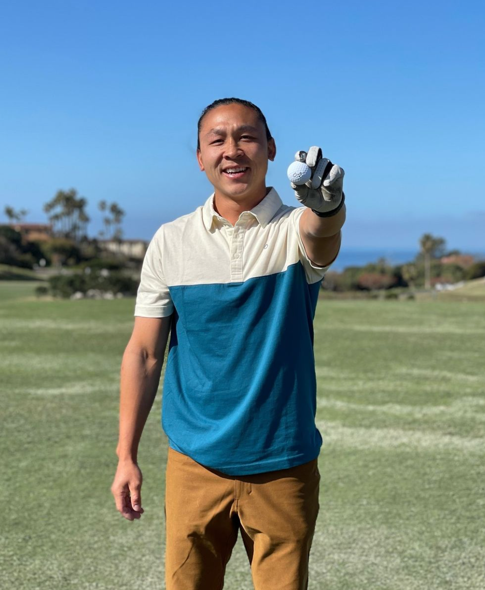 Amateur Golfer Holding a Cut Blue Golf Ball in Front of Him