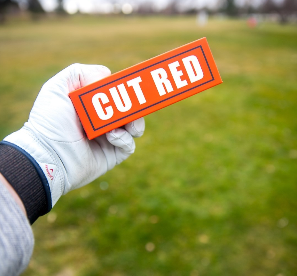 Golfer Holding a Sleeve of Cut Red Golf Balls