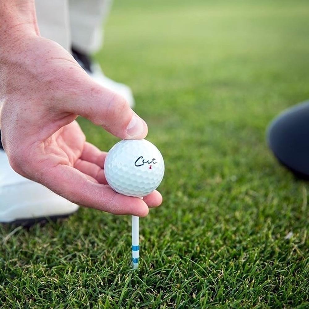 Cut Blue 4 Piece Golf Ball Being Placed On a Tee