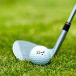 Cut Red Golf Ball With An Iron Club Behind It