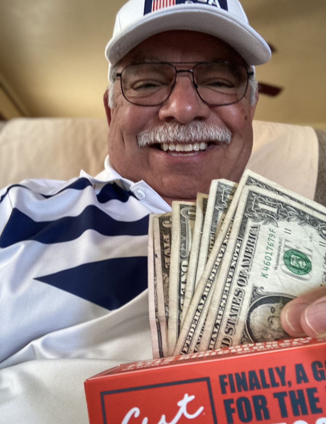 Golfer Holding Money He Saved and a Sleeve of Cut Red Golf Balls
