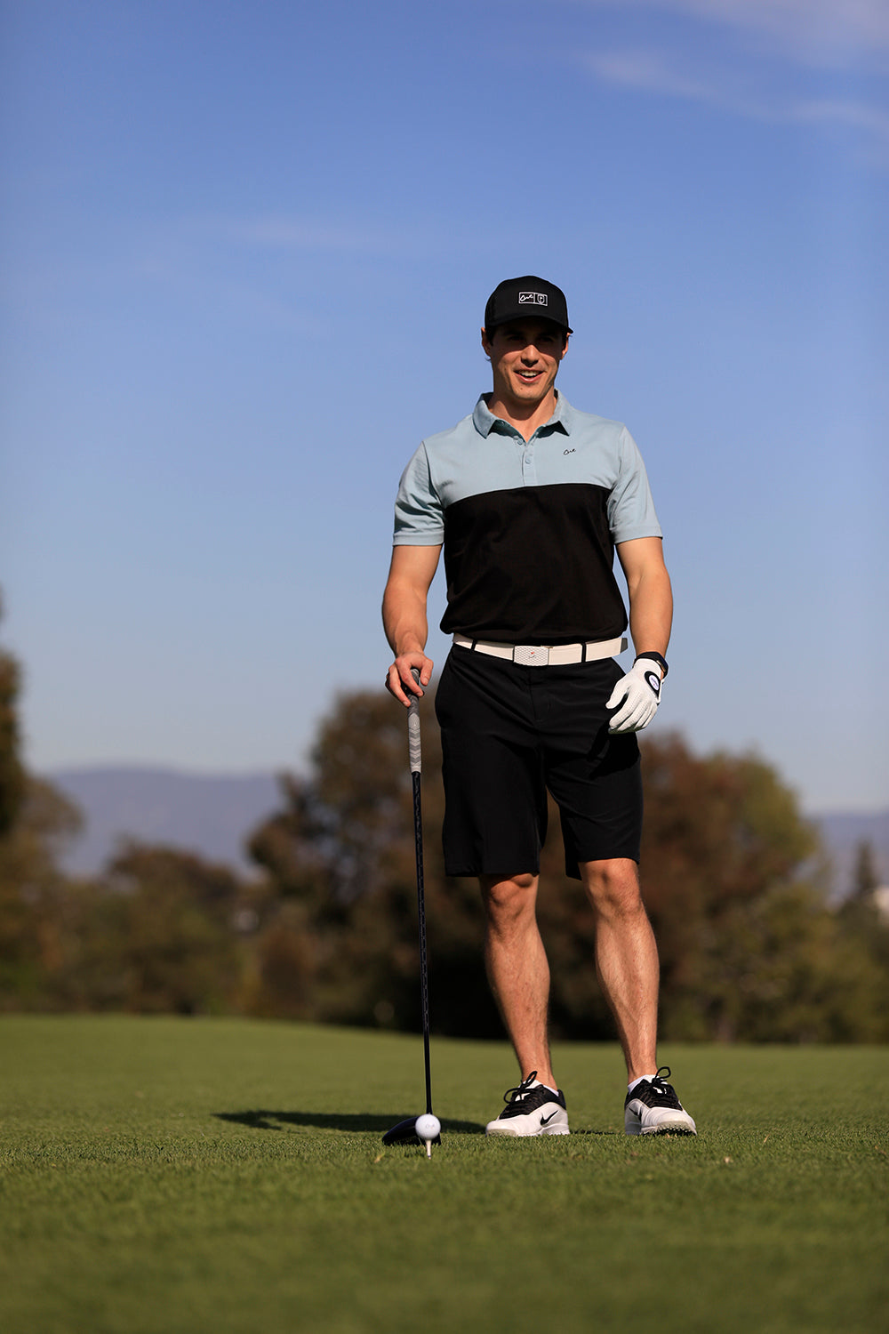 Golfer Wearing a Cut Golf Logan Black Polo Shirt