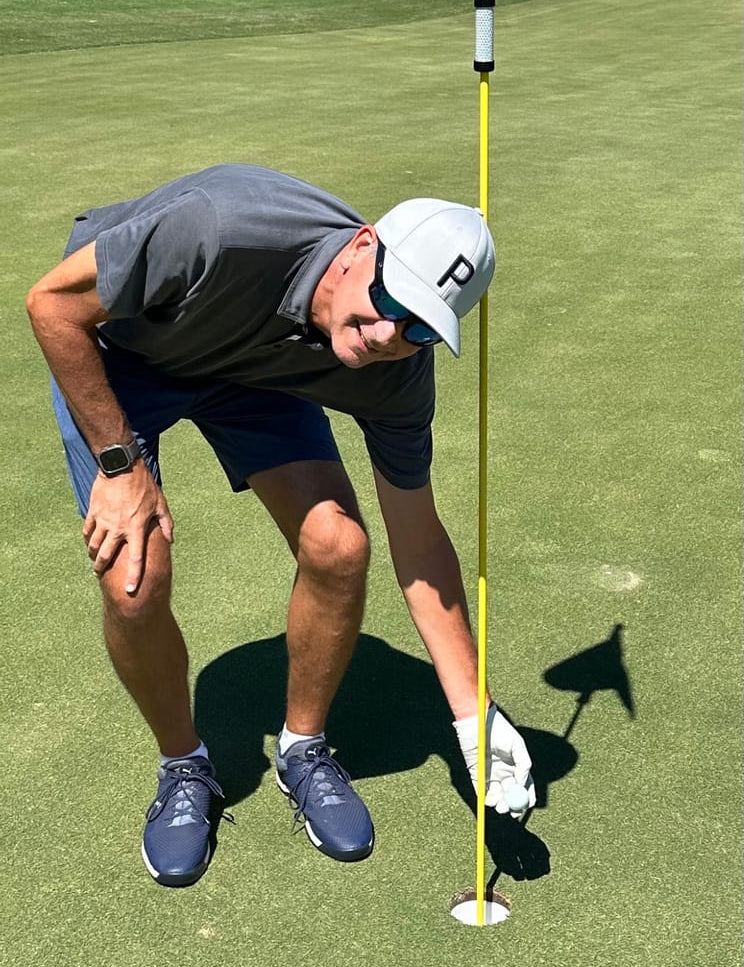 Amateur Golfer Taking His Cut DC Ball Out of the Hole