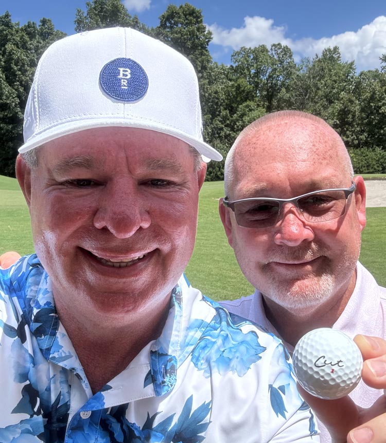 Smiling Golfer Holding a Cut DC Dual Core Ball With Partner